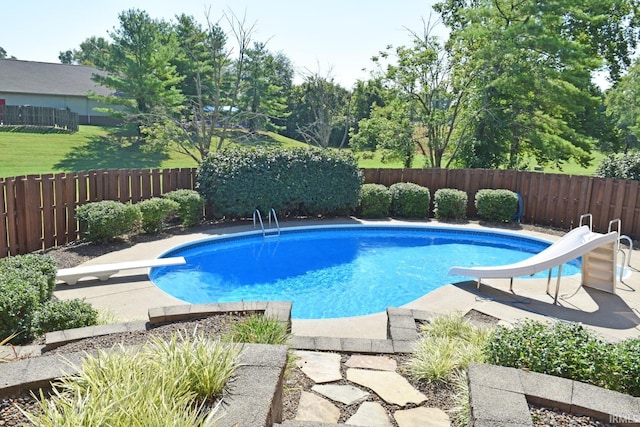 view of pool with a water slide, a diving board, and a patio