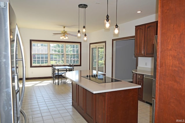 kitchen with appliances with stainless steel finishes, hanging light fixtures, a center island, ceiling fan, and light tile patterned flooring