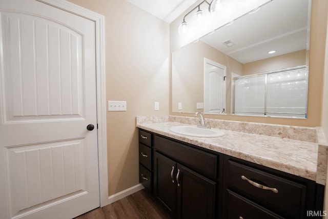 bathroom featuring a shower, vanity, and hardwood / wood-style flooring