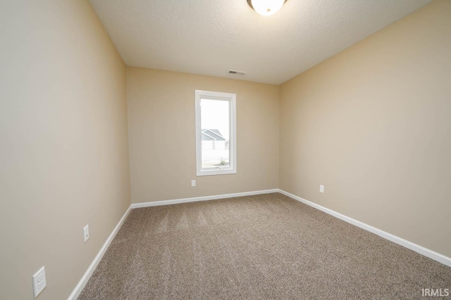 carpeted empty room featuring a textured ceiling