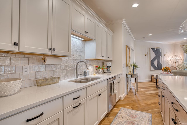 kitchen with ornamental molding, dishwasher, sink, and light hardwood / wood-style floors