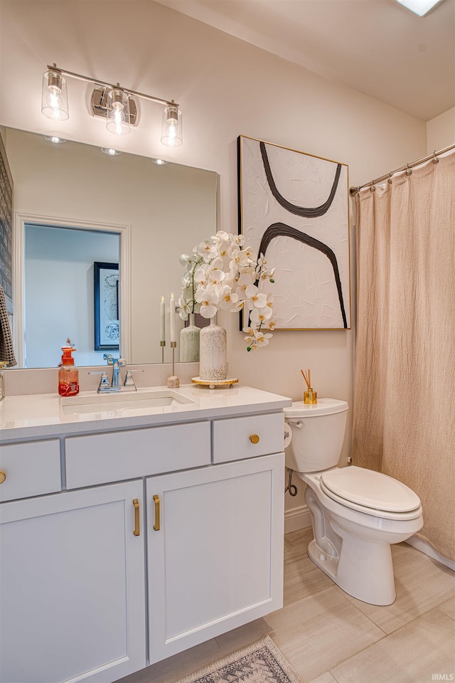 bathroom with tile patterned flooring, toilet, and vanity