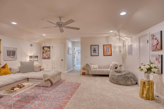 living room featuring ceiling fan, light carpet, and vaulted ceiling