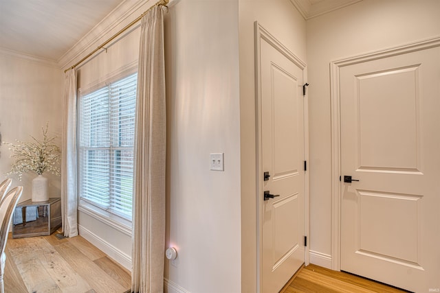 entryway with crown molding and light hardwood / wood-style flooring