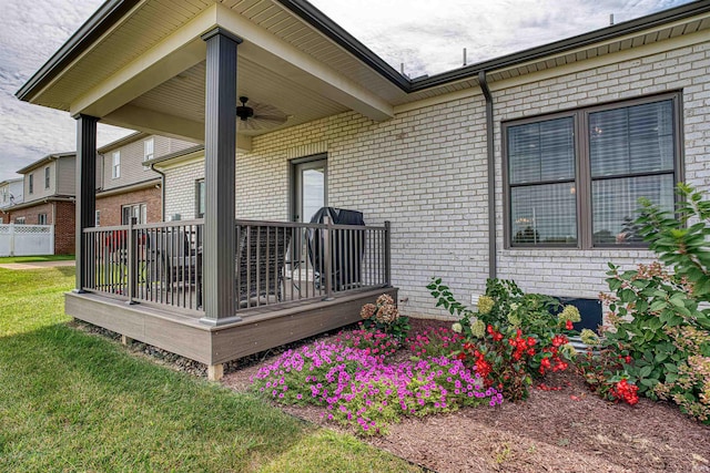 exterior space with ceiling fan, a yard, and a deck