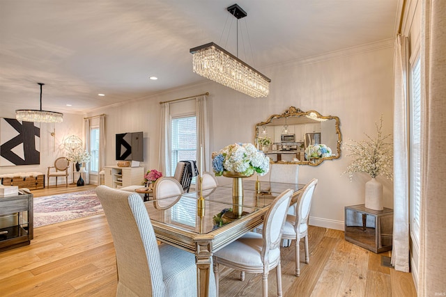 dining area featuring an inviting chandelier, crown molding, and light hardwood / wood-style flooring