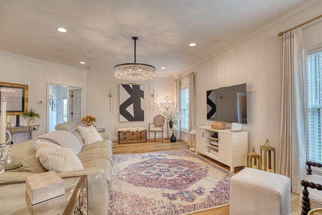 living room with light hardwood / wood-style floors, a notable chandelier, and ornamental molding