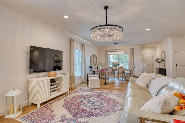 living room with a chandelier, light hardwood / wood-style floors, and ornamental molding