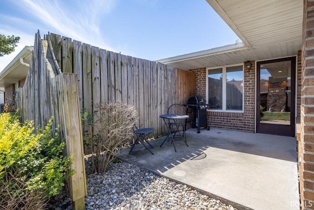 view of patio with area for grilling and fence