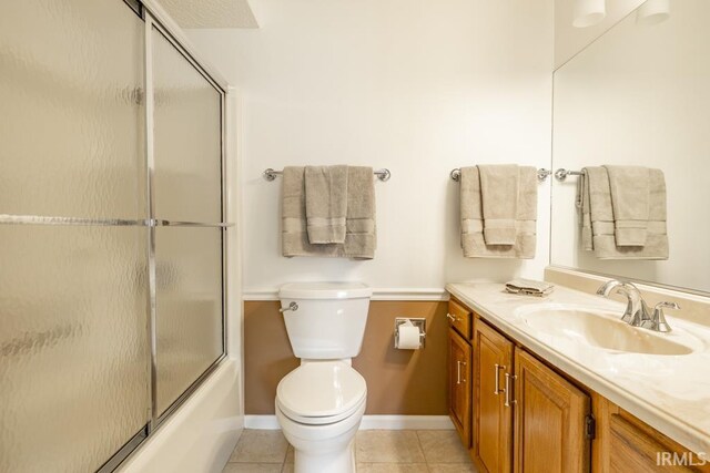 full bathroom with shower / bath combination with glass door, vanity, toilet, and tile patterned floors