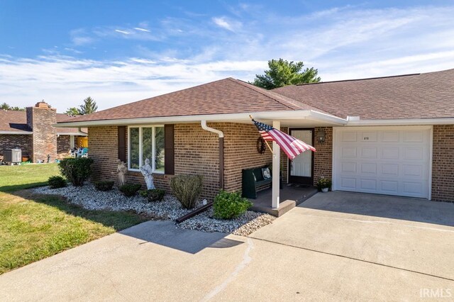 ranch-style home featuring a garage and a front lawn