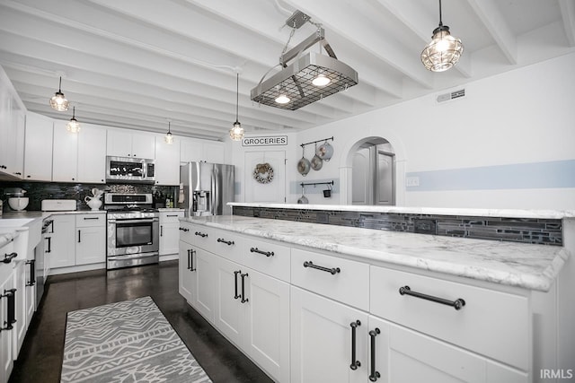 kitchen with beamed ceiling, light stone countertops, appliances with stainless steel finishes, hanging light fixtures, and white cabinets