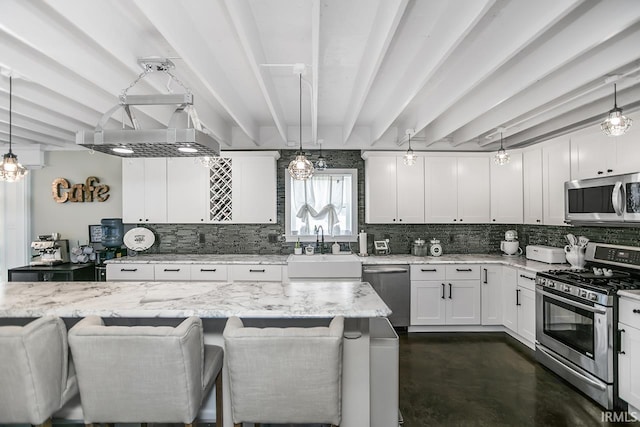 kitchen featuring appliances with stainless steel finishes, beamed ceiling, decorative light fixtures, and a breakfast bar