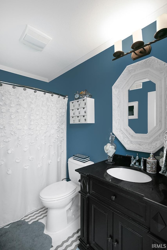 bathroom with ornamental molding, vanity, and toilet