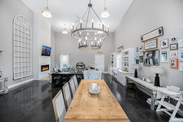 dining area featuring a large fireplace, an inviting chandelier, and vaulted ceiling