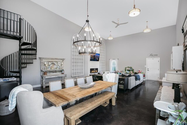 16084 County Road 20, Goshen, IN 46528 - dining space featuring stairs, high vaulted ceiling, a chandelier, baseboards, and concrete flooring