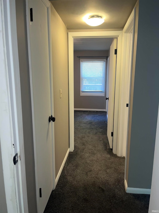 hallway featuring dark carpet