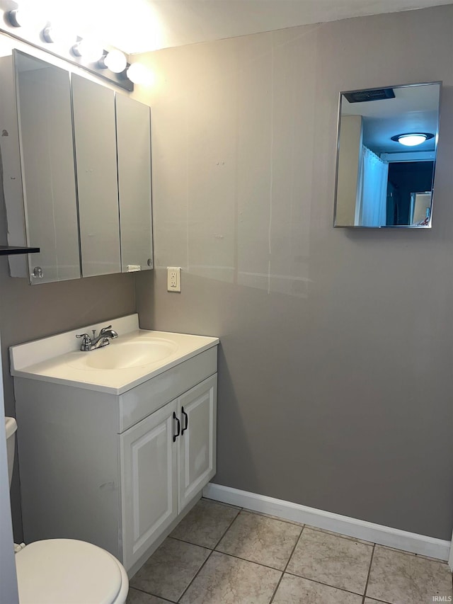 bathroom with tile patterned flooring, vanity, and toilet