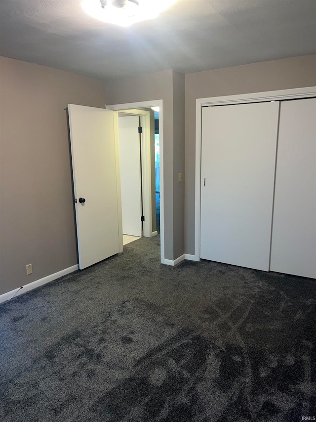 unfurnished bedroom with a closet and carpet floors