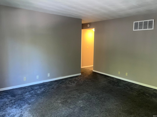 spare room with dark colored carpet