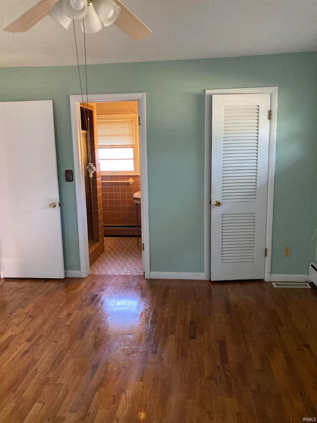 unfurnished bedroom with dark hardwood / wood-style flooring and ceiling fan