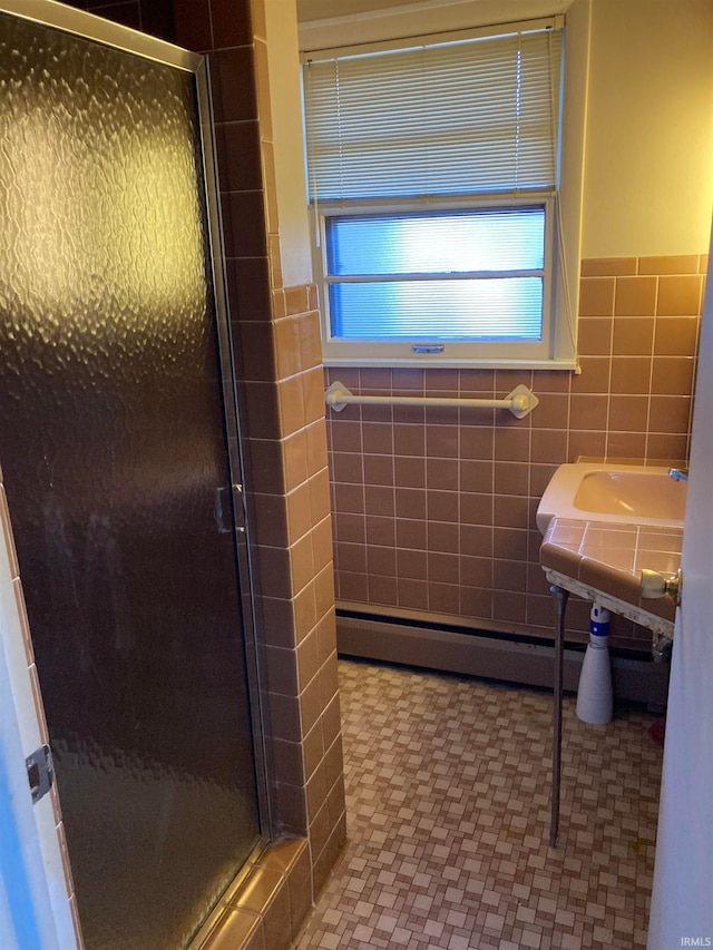 bathroom with tile walls, walk in shower, and baseboard heating