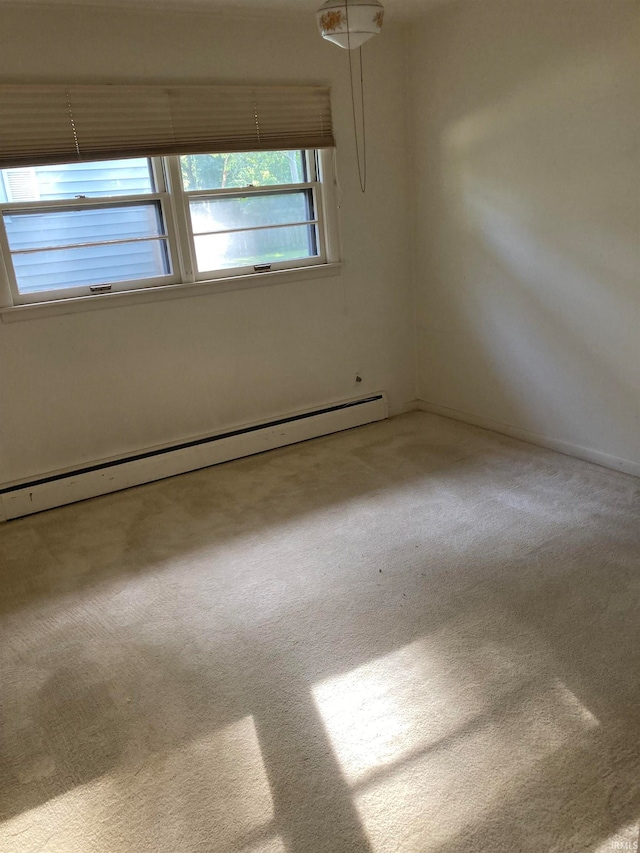 carpeted empty room featuring a baseboard radiator