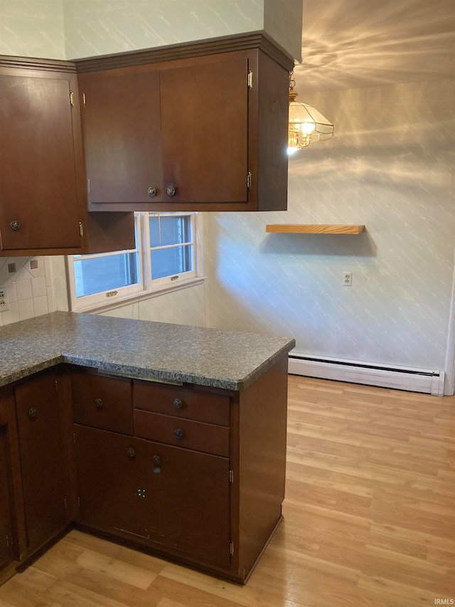 kitchen with light wood-type flooring, a baseboard radiator, and dark brown cabinetry