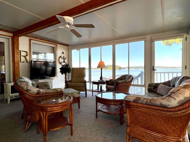 living room featuring beamed ceiling, ceiling fan, and carpet floors