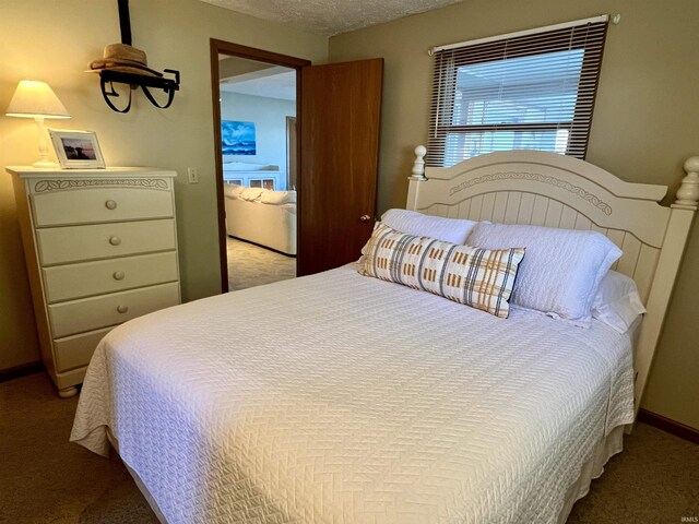 bedroom with baseboards, a textured ceiling, and light colored carpet