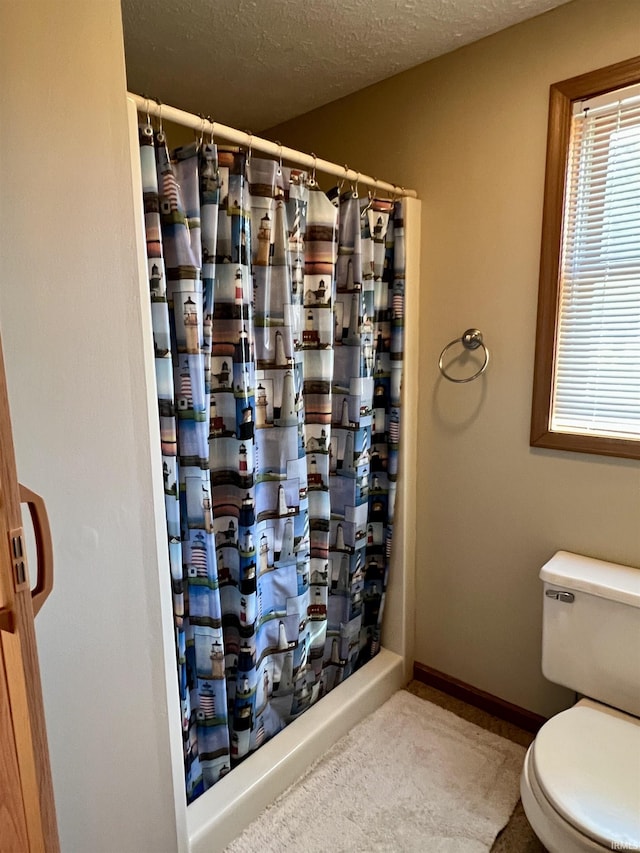 full bath with a textured ceiling, baseboards, toilet, and a shower with curtain