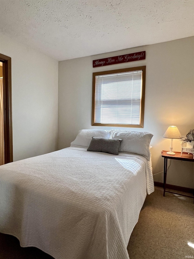 carpeted bedroom with a textured ceiling and baseboards