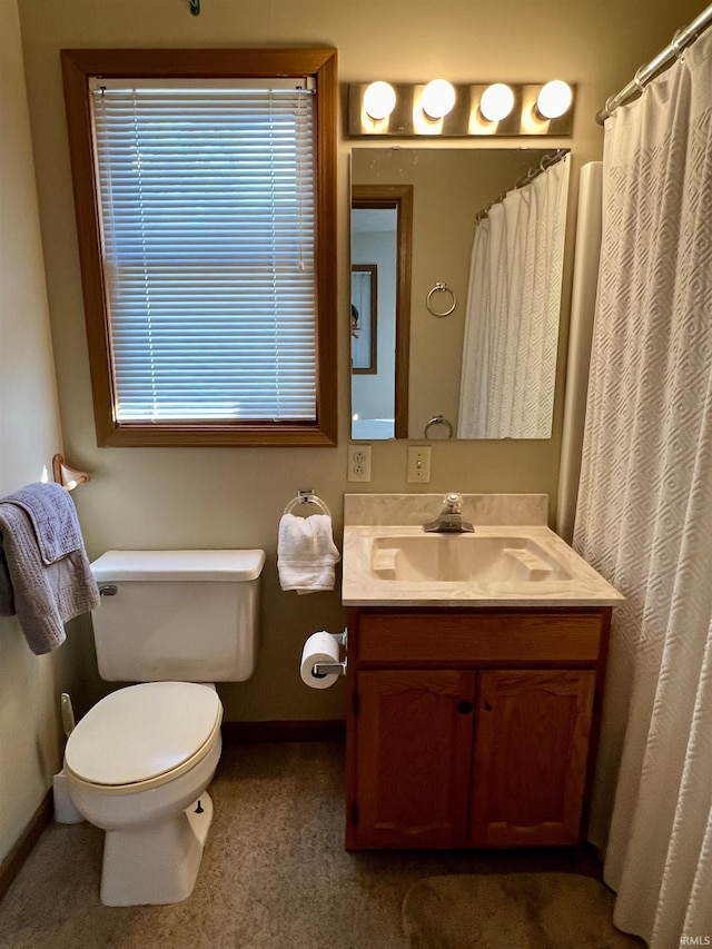 full bathroom with toilet, vanity, and baseboards