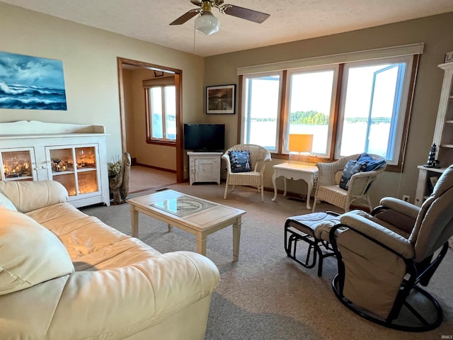 carpeted living room with ceiling fan and a textured ceiling