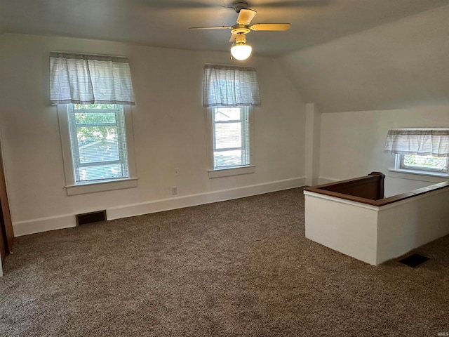 additional living space with ceiling fan, lofted ceiling, and dark colored carpet