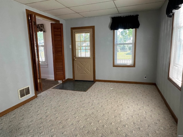 carpeted foyer with a drop ceiling