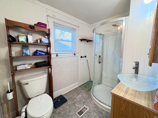 bathroom featuring vanity, an enclosed shower, and toilet