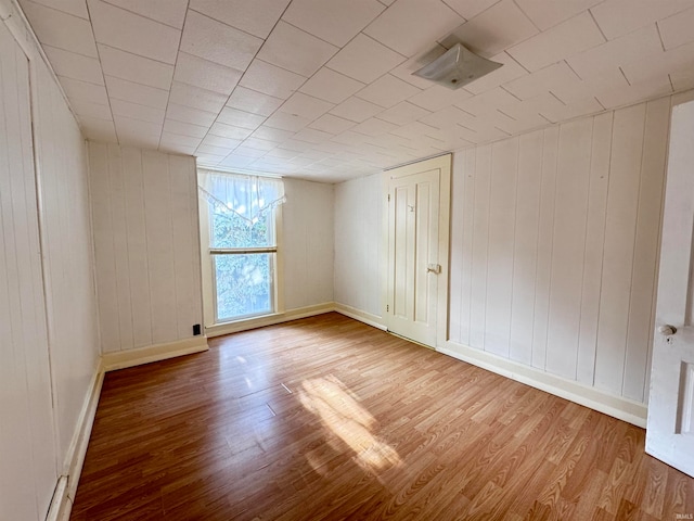 empty room featuring hardwood / wood-style flooring and wood walls