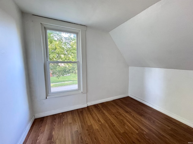 bonus room with dark wood-type flooring and vaulted ceiling