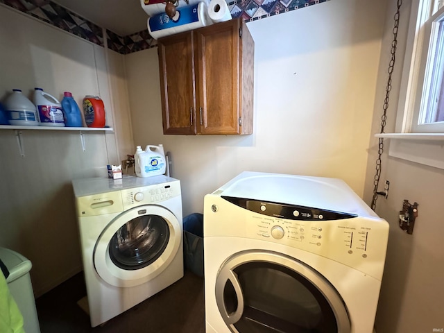 clothes washing area featuring cabinets and washer and clothes dryer