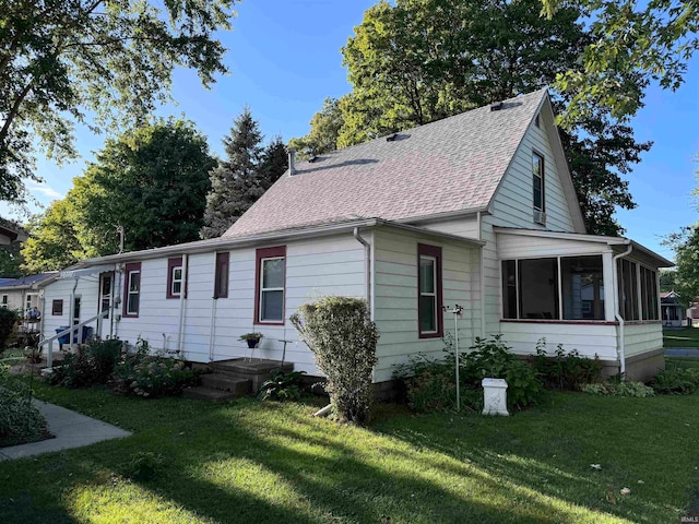 view of front of home with a sunroom and a front yard