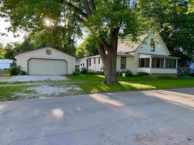 view of front of house with a sunroom, a garage, and a front lawn