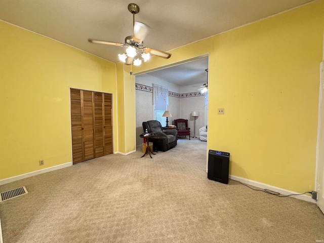 living area with ceiling fan and carpet floors