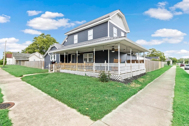 farmhouse inspired home featuring a front lawn, ceiling fan, and covered porch