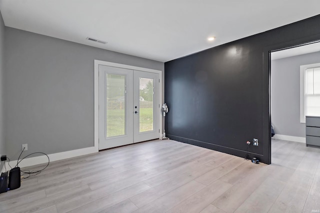 spare room with french doors and light hardwood / wood-style floors