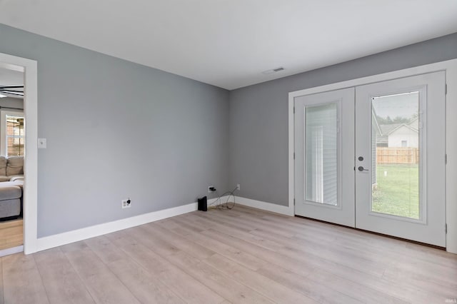 empty room featuring light wood-type flooring and french doors