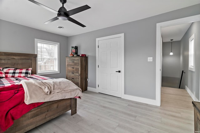 bedroom with multiple windows, ceiling fan, and light hardwood / wood-style flooring