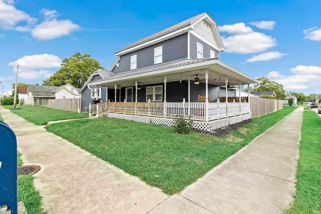 farmhouse-style home with a porch, ceiling fan, and a front lawn