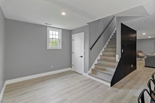 basement with light hardwood / wood-style flooring