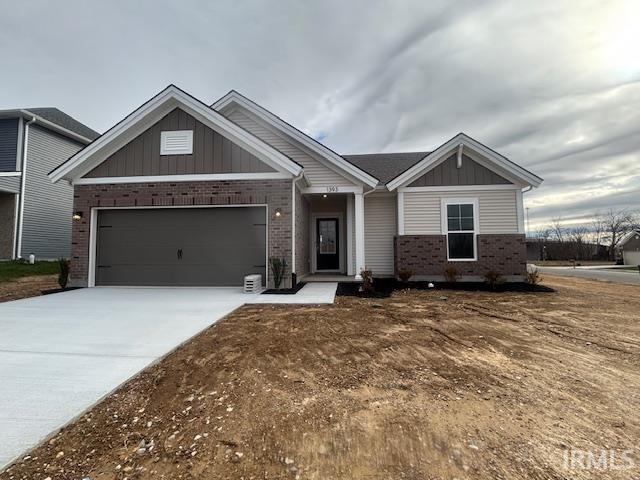 view of front of house featuring brick siding, board and batten siding, concrete driveway, and a garage